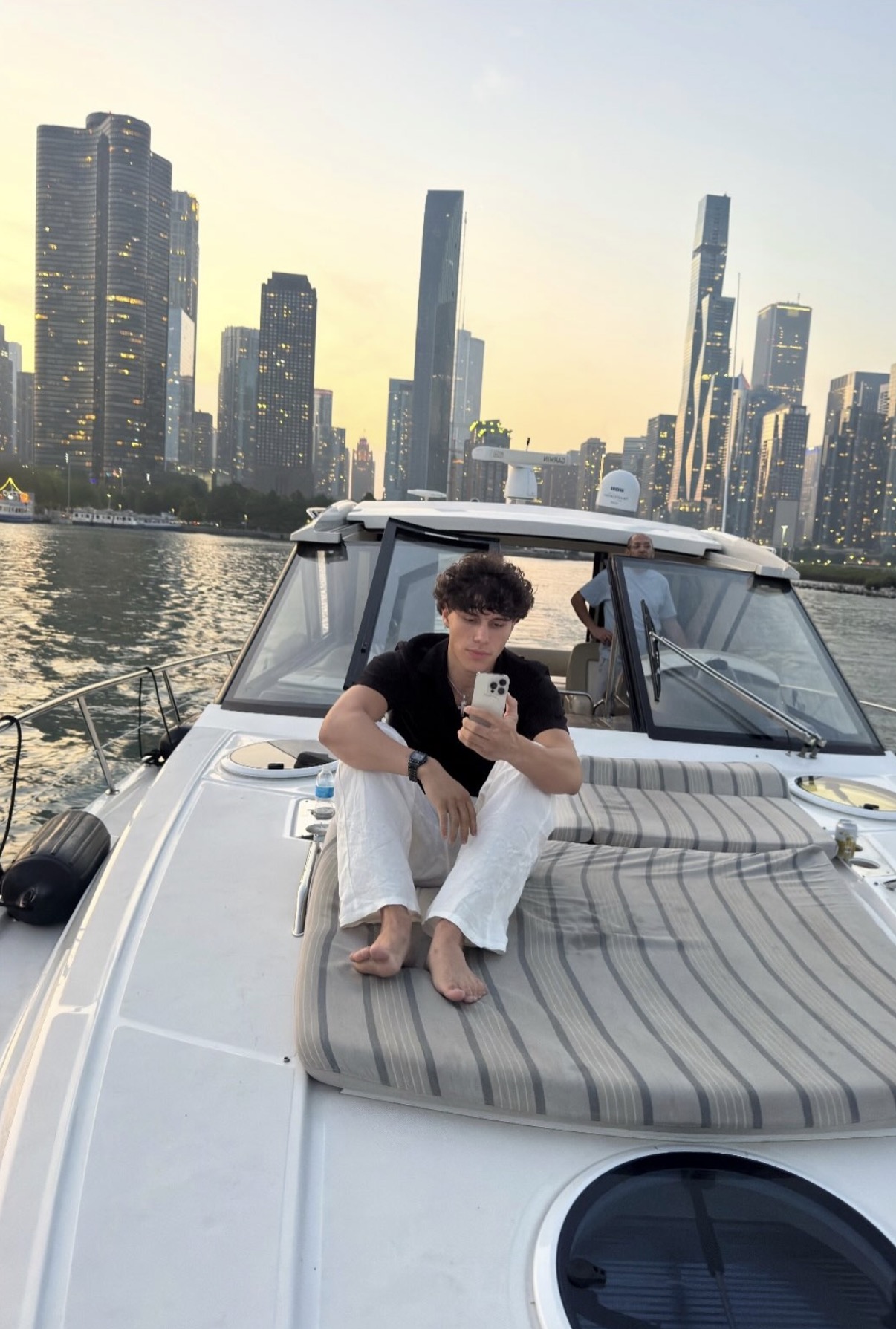 Lucian Pickett on a boat in front of the city skyline